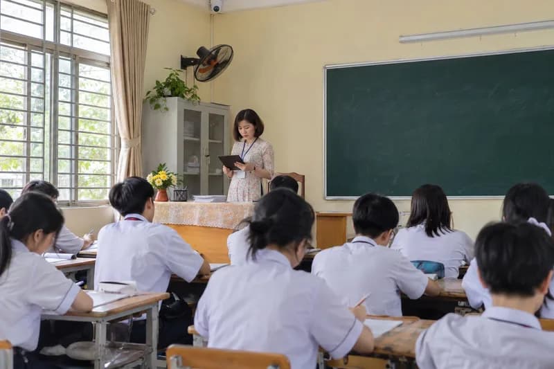 Cô giáo xem sĩ số lớp trên máy tính bảng, camera gắn ở góc trần lớp học